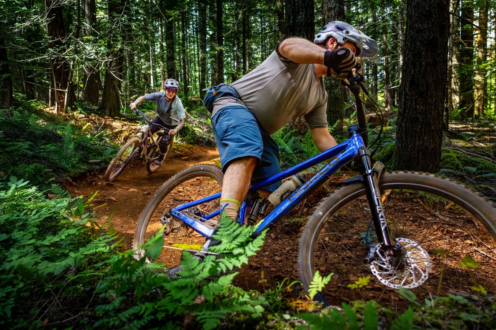two rider on the new Norco Fluid riding a singletrack trail in the forest.