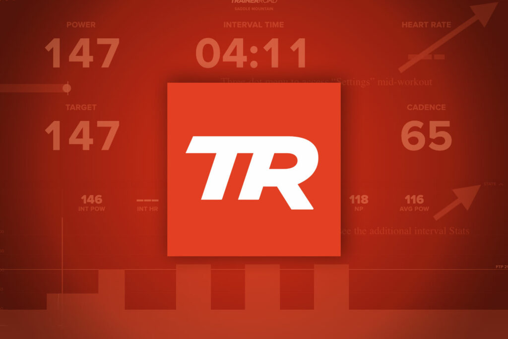 Cyklista tréninkem na stacionárním trenažéru s aplikací TrainerRoad v domácím prostředí