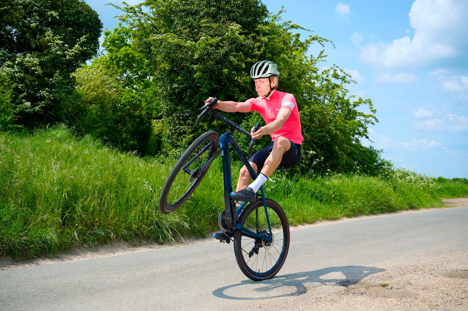 Cyklista jedoucí po terénu s rukama na řídítkách, demonstrující ovládání kola